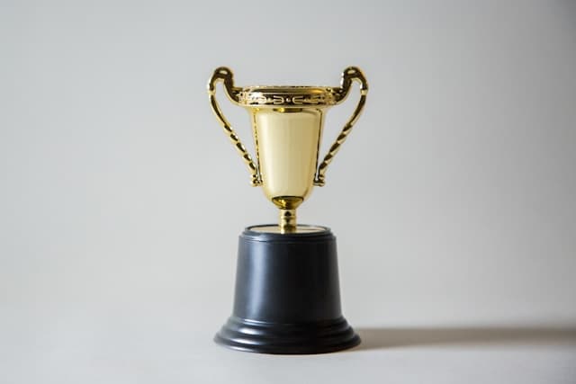 small golden trophy with black base in a white background